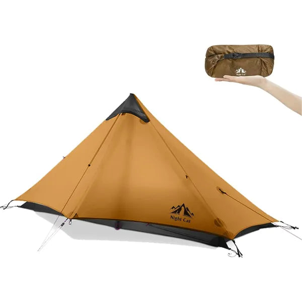 Night Cat ultralight tent set up in tan colour, with compact carry bag held in hand to show size and portability.