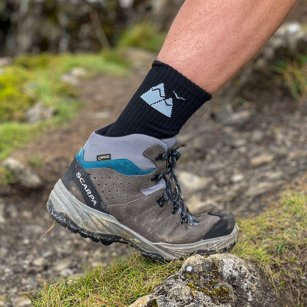 Hiker wearing HikeWare merino hiking socks and Scarpa boots on a mountain trail