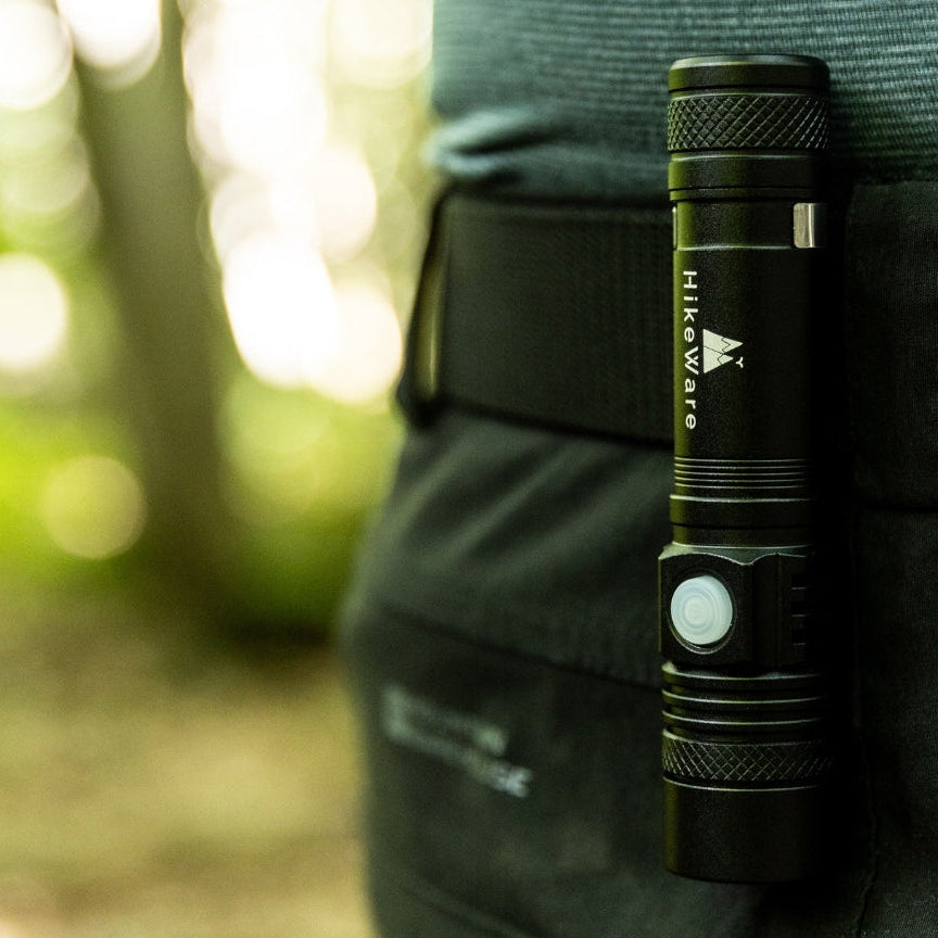 HikeWare rechargeable flashlight mounted on a belt during an outdoor hike