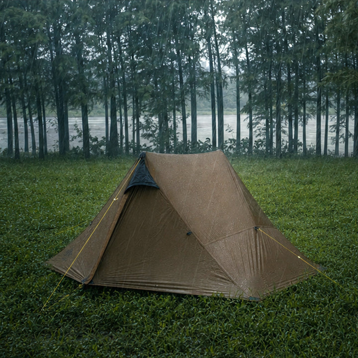 Night Cat 2 Person Tent in Khaki pitched in the rain beside a forest lake, showing the two-pole ridge shape 